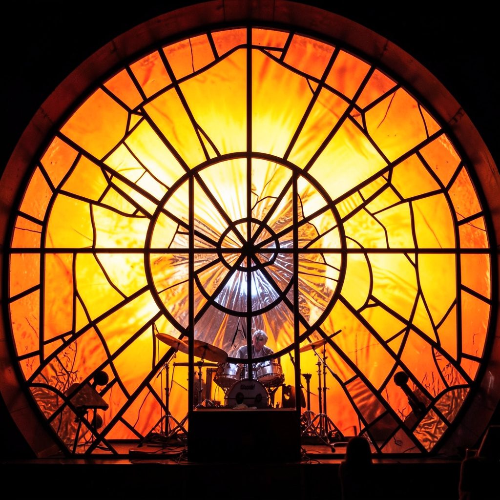 Soft amber stage light cutting through cool blue haze, evocative of a live concert moment, atmospheric and editorial